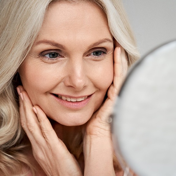 A middle-aged woman admiring her appearance after a PDO thread lift